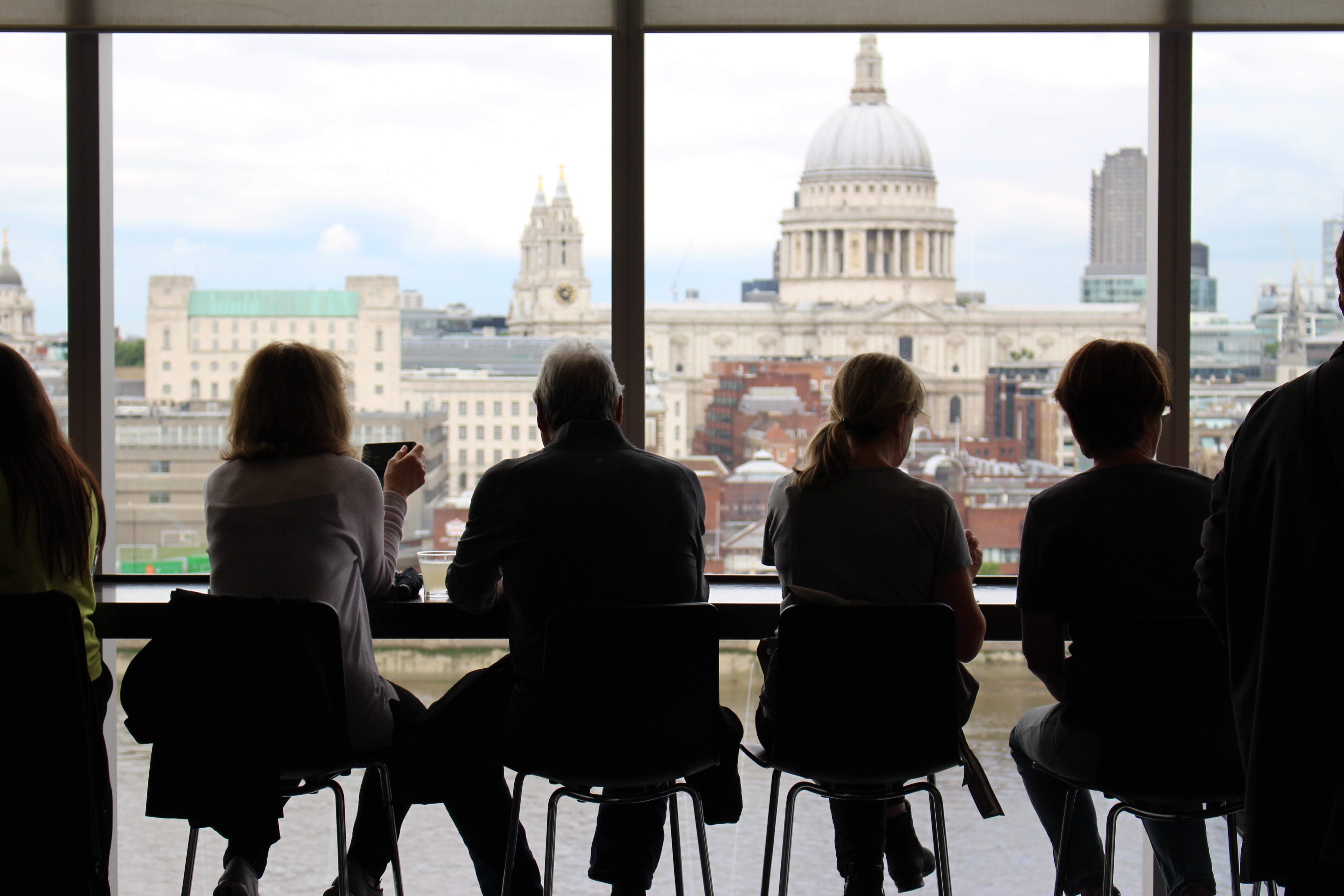 image of people sitting at a window table looking out at a city