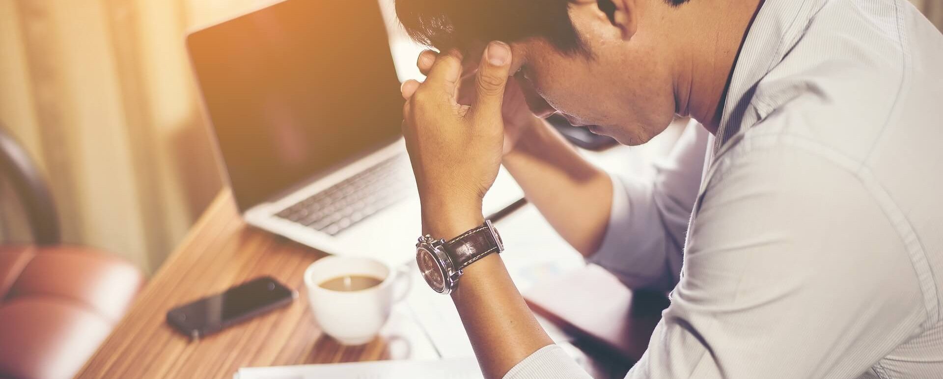 Man worried and stressed whilst on his desk