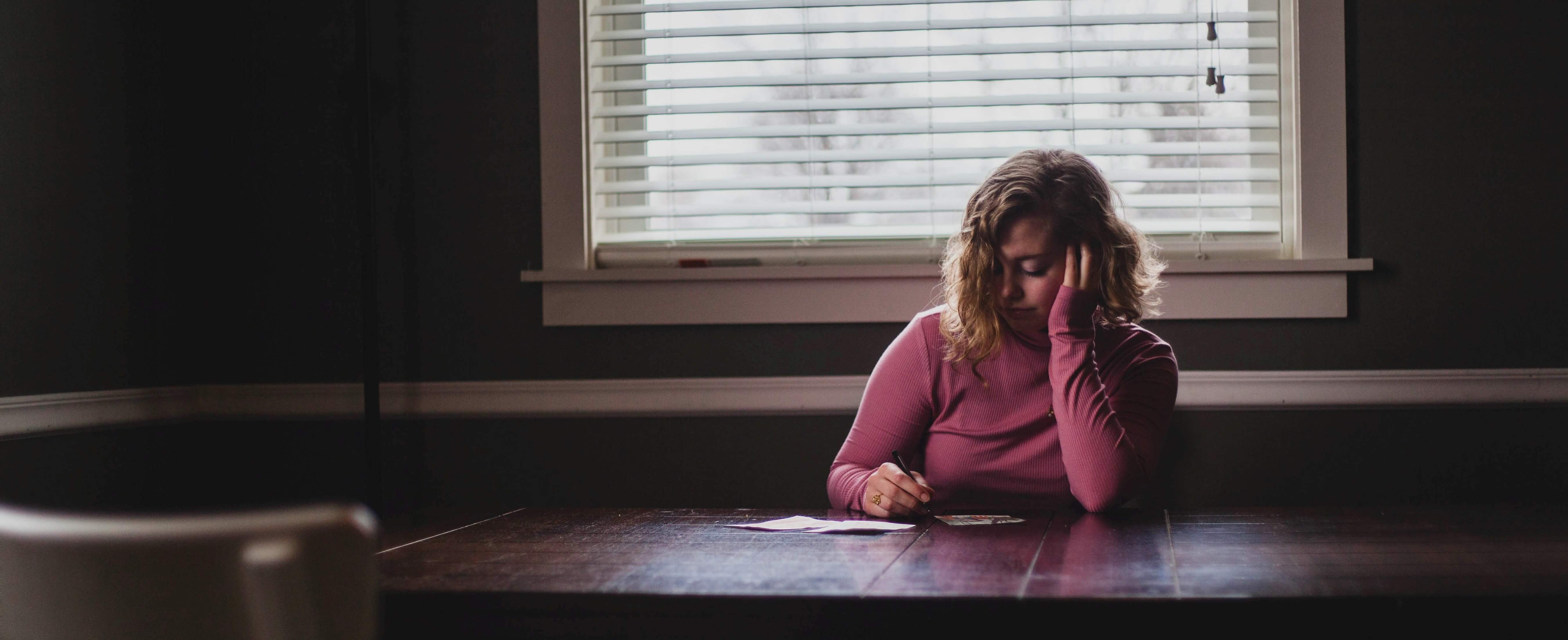 Woman looking down on a list in a dim room