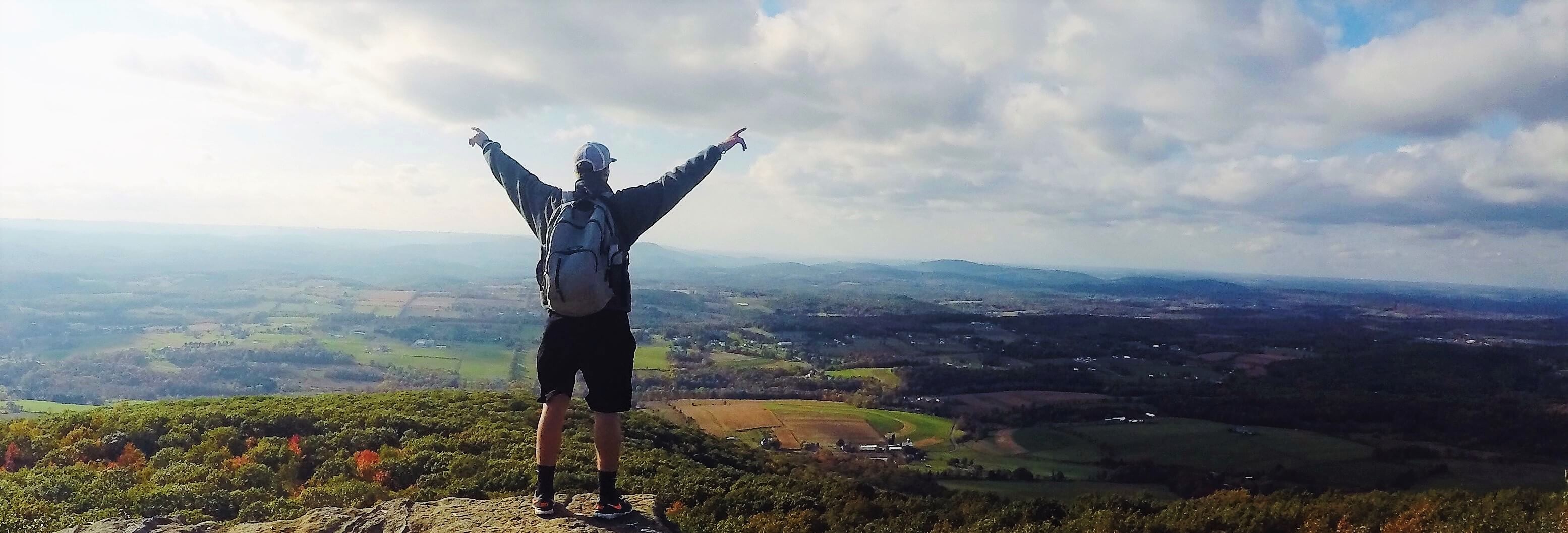 A man reaching the summit of a mountain