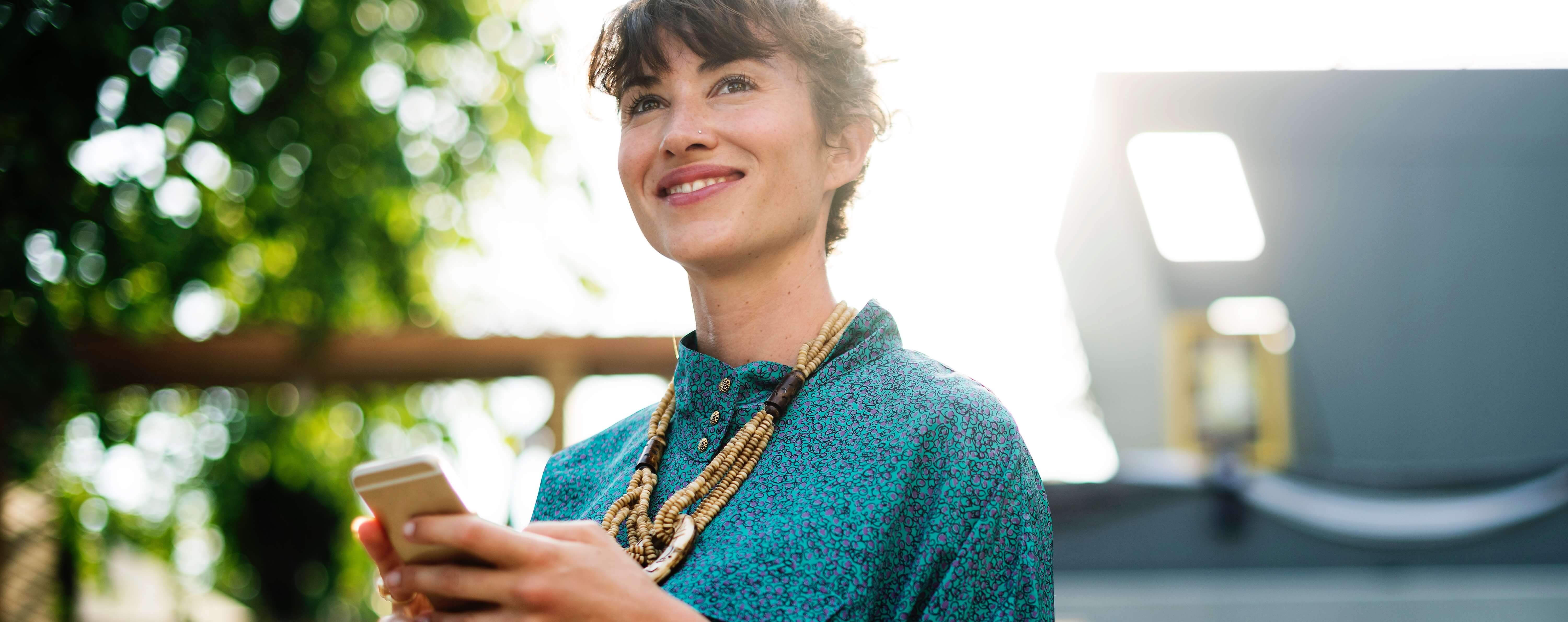 A woman looking relaxed and pleased while holding her cellphone